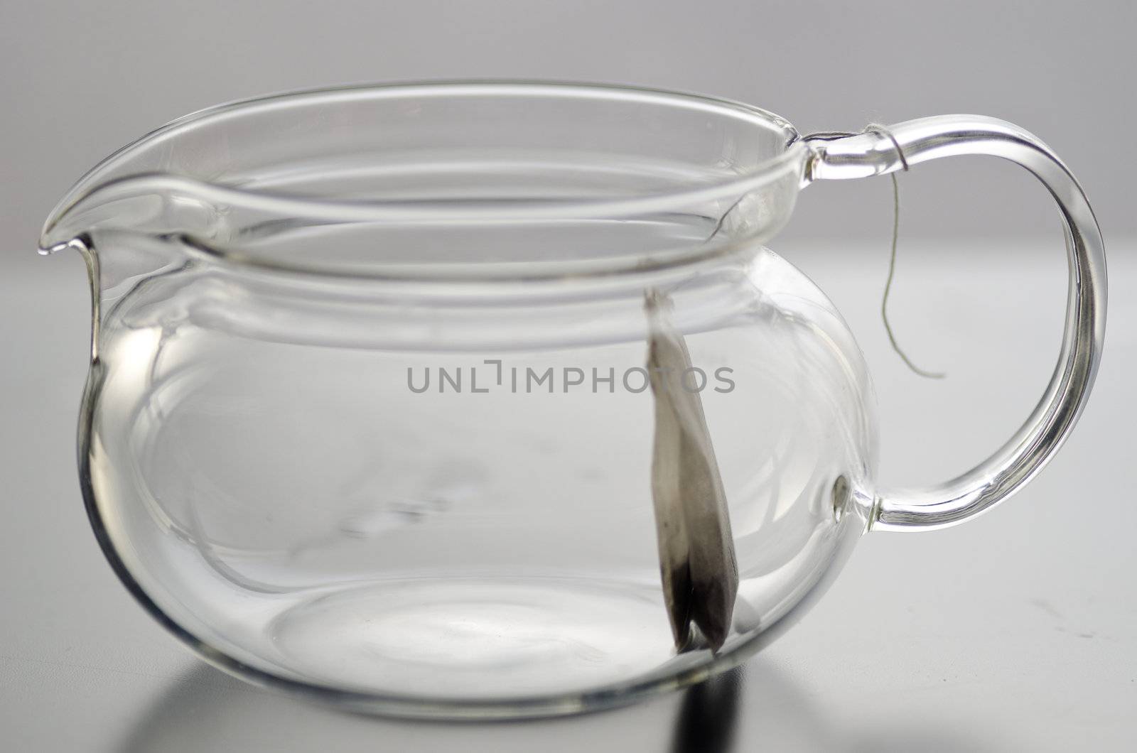 Empty glass tea pot with herb tea tea bag