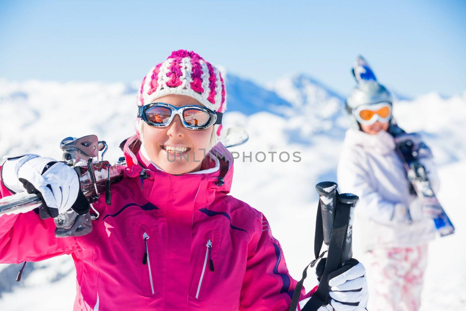 Young woman with skis and a ski outfit in the Zillertal Arena, Austria