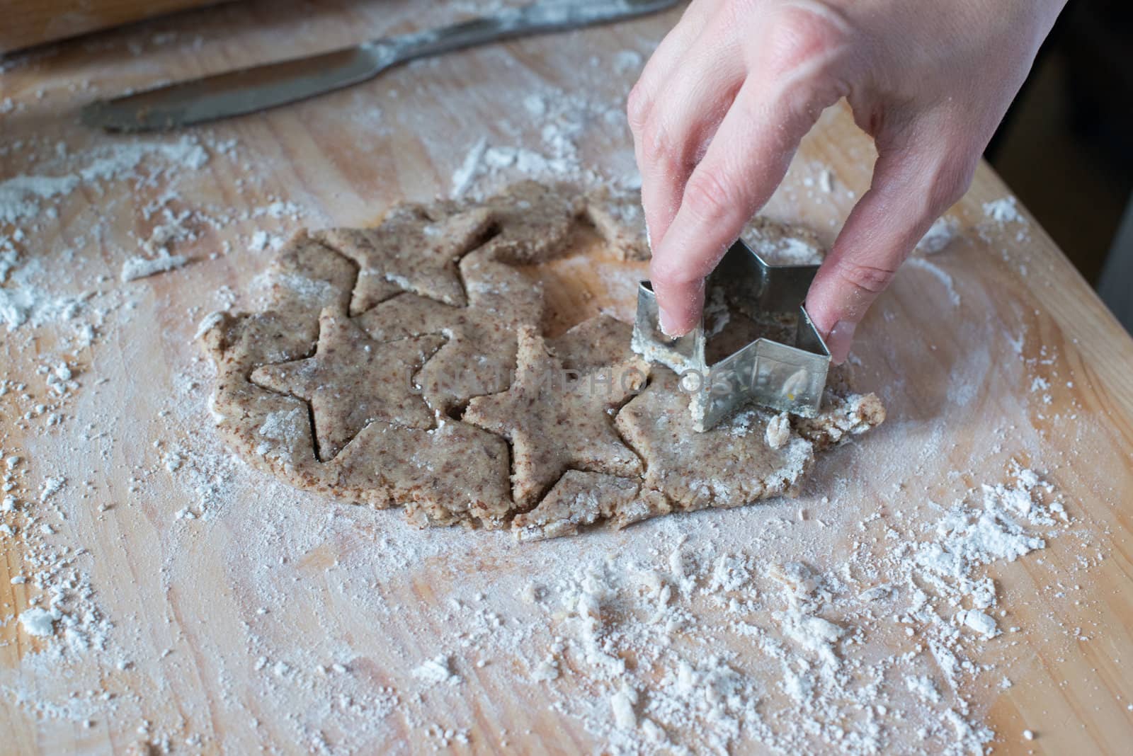 Cutting homemade Christmas cookies dough with star shape