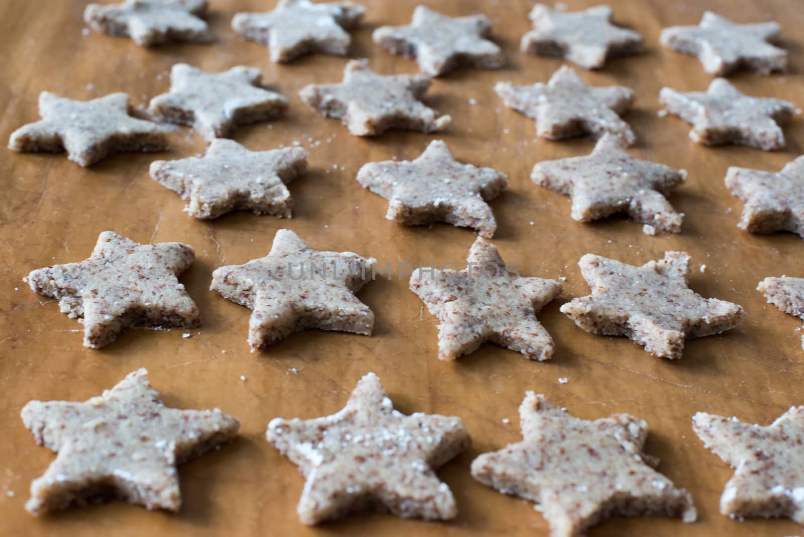 Cut star shaped homemade Christmas cookies arranged on a baking tray
