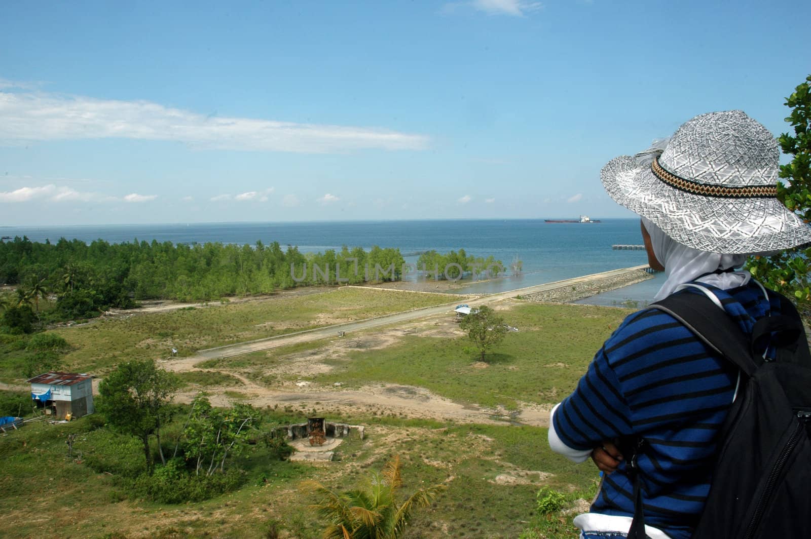 a woman looking out to sea from the top of the hill