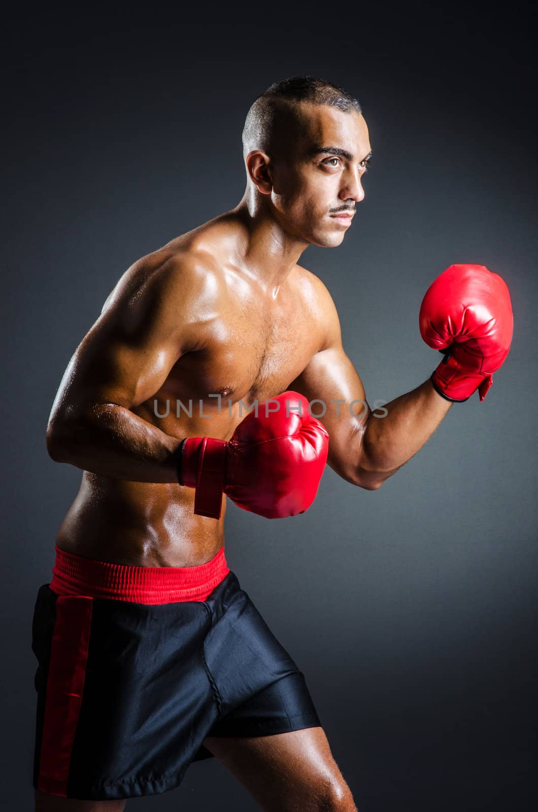 Boxer with red gloves in dark room