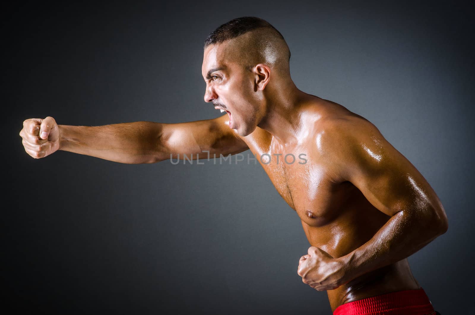 Muscular boxer in dark studio by Elnur