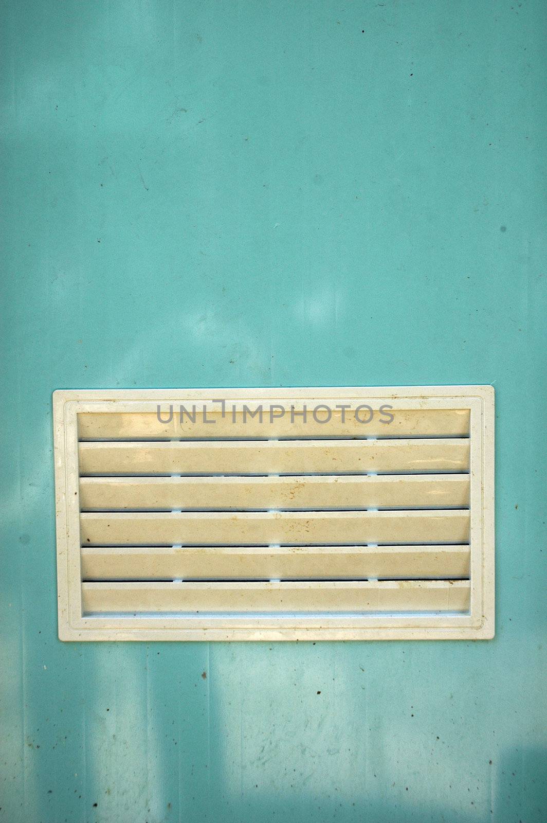a dirty white ventilation window on light blue plastic door