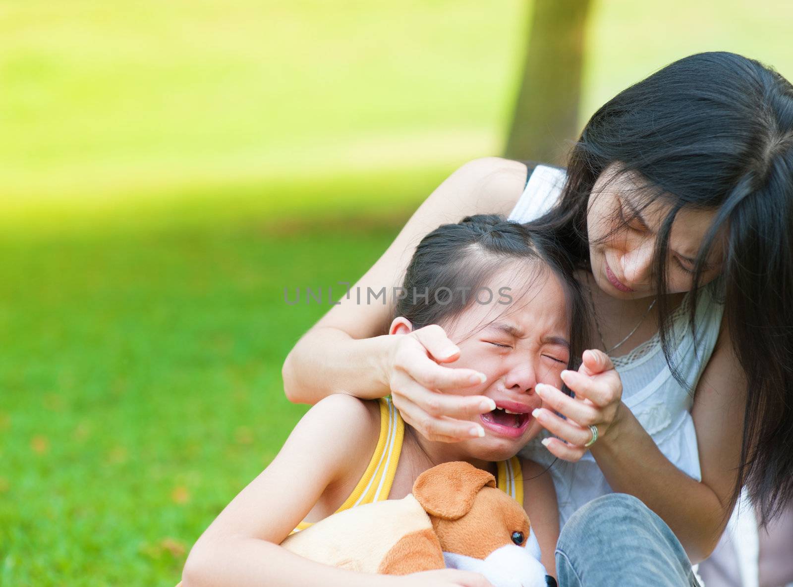 Asian mother is comforting her crying daughter