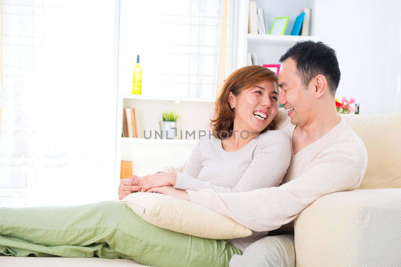 Happy Asian couple having fun time at home