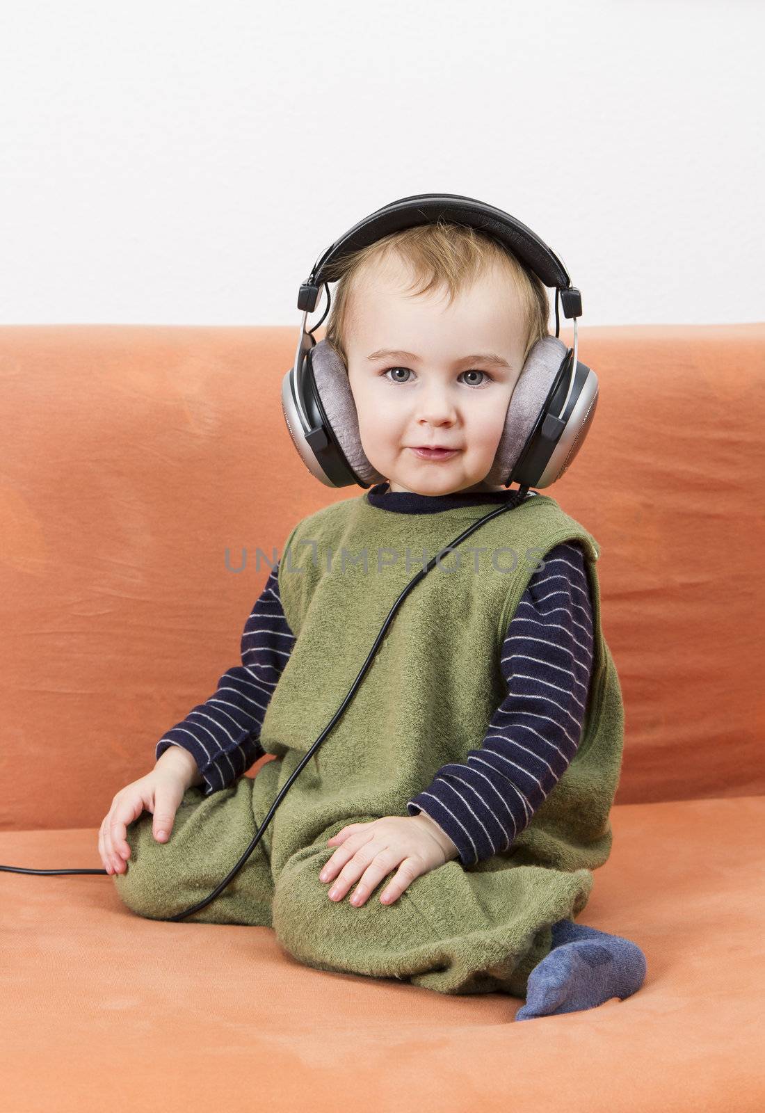 young child on couch with big earphone