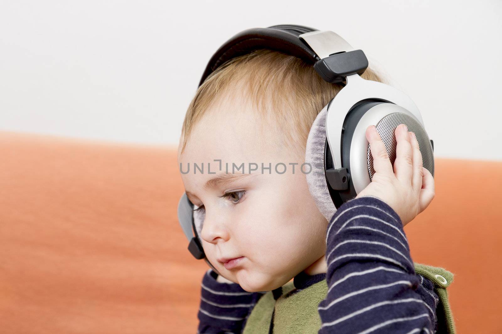 young child on couch with headphone by gewoldi