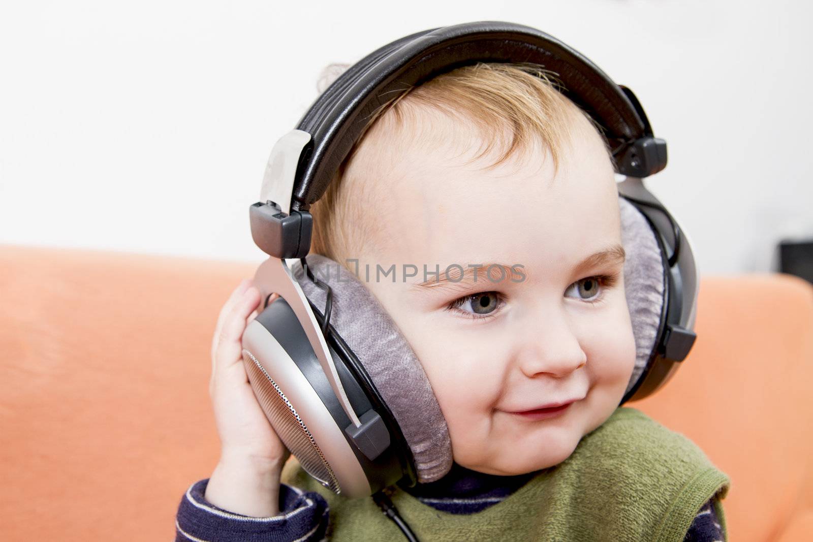 young child on couch with headphone by gewoldi