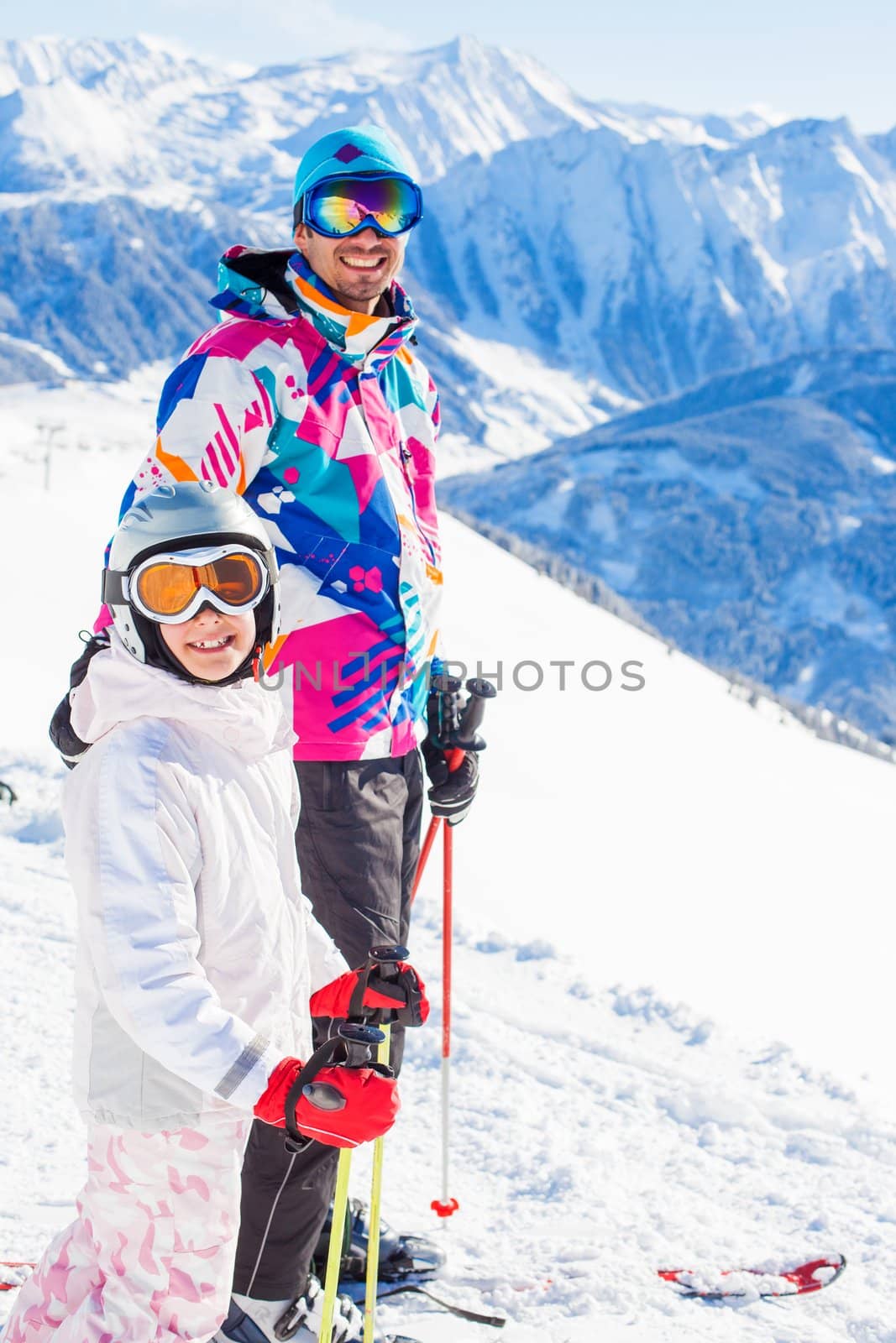 Happy smiling girl in ski goggles and with her father, Zellertal, Austria. Focus on the girl