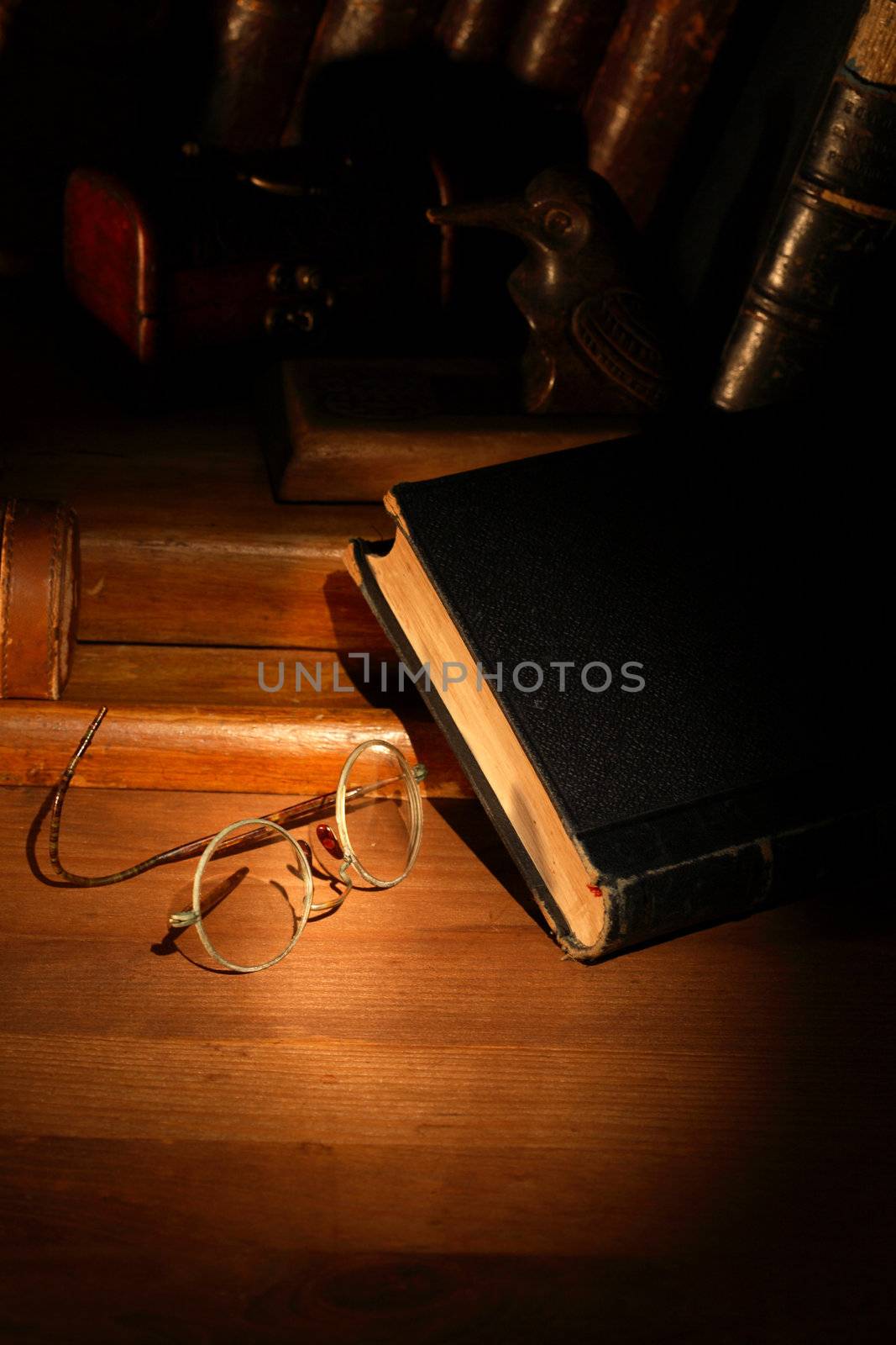 Vintage still life with old spectacles near book on wooden surface