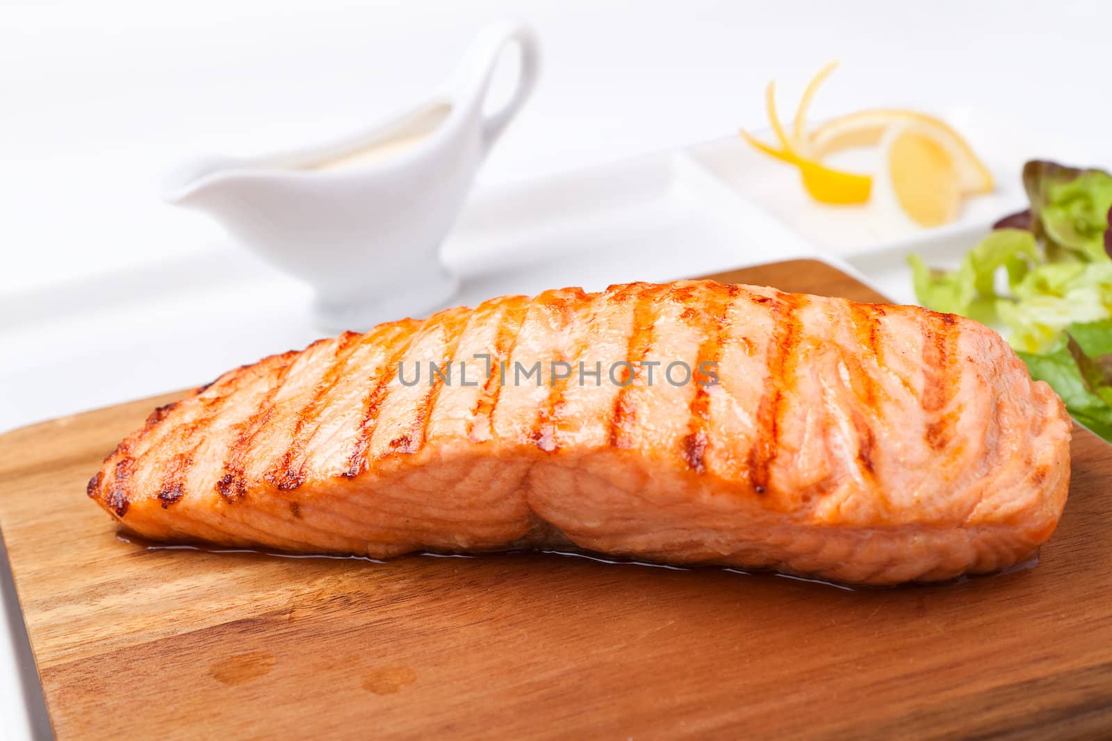 piece of steak grilled fish on a wooden board