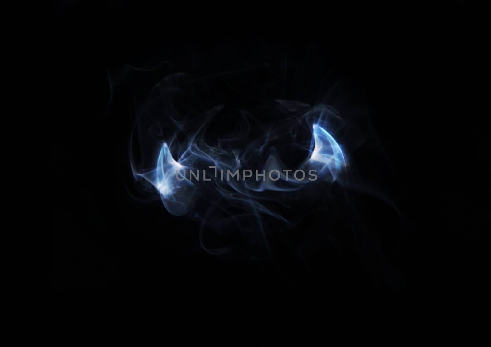 devil horns of smoke on a black background