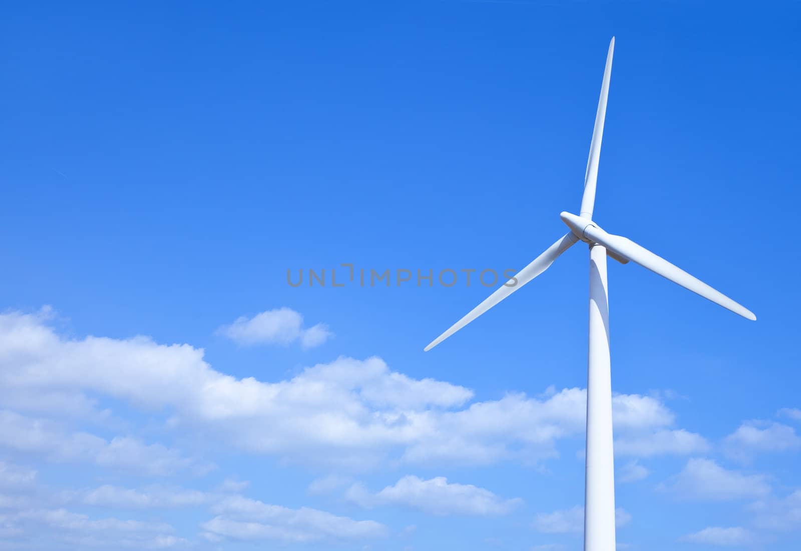 Wind turbine set against a blue sky
