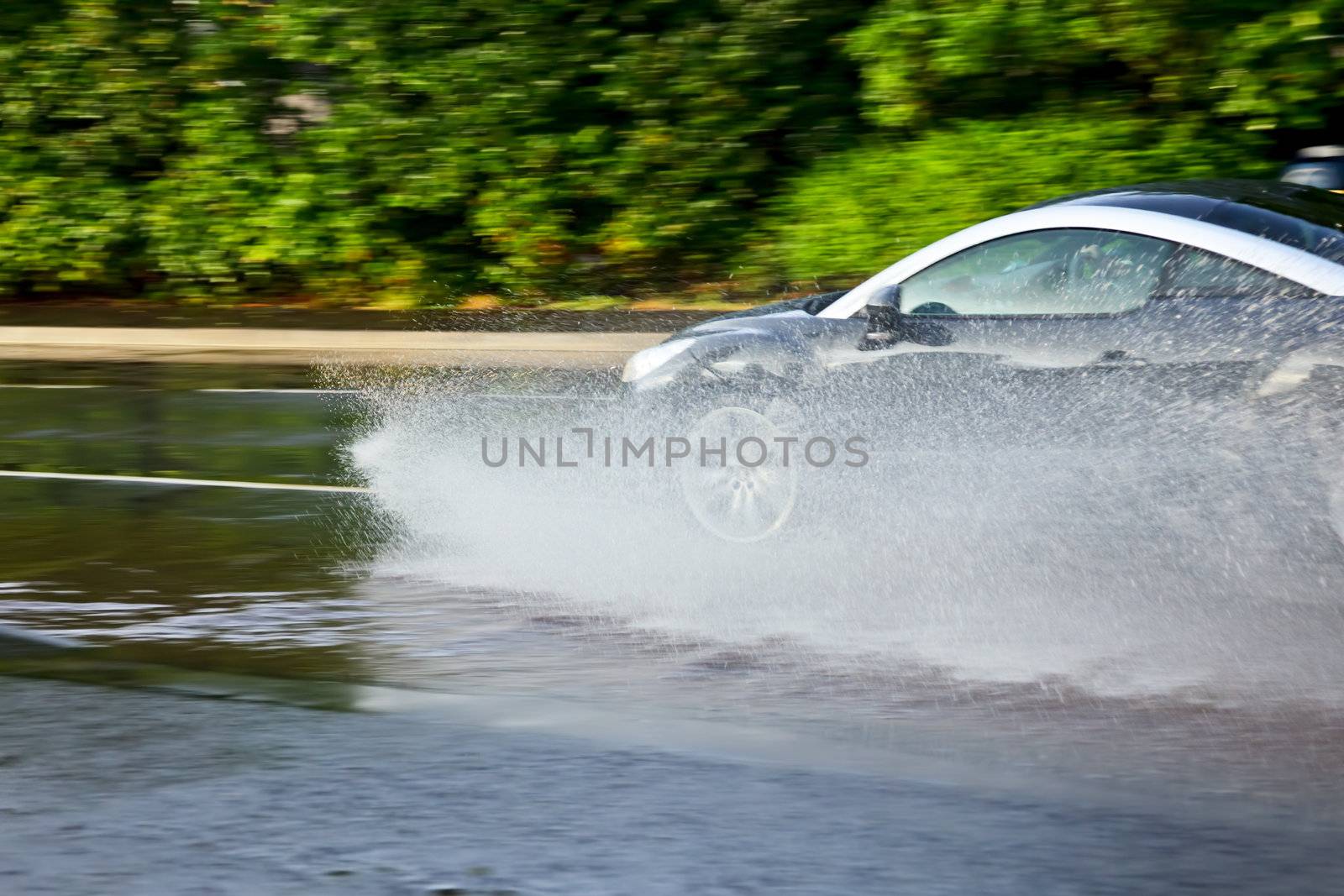 Moving car splashes on a flooded street