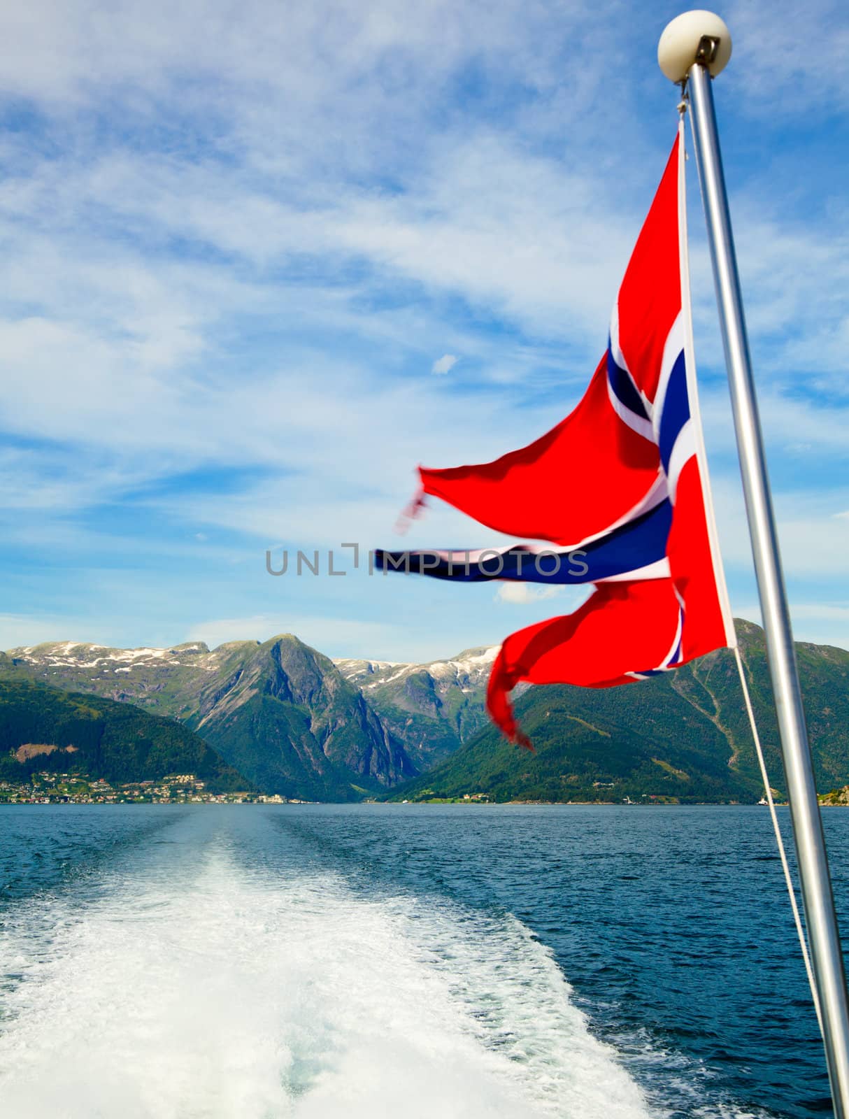 Norwegian flag against fjord mountains by naumoid