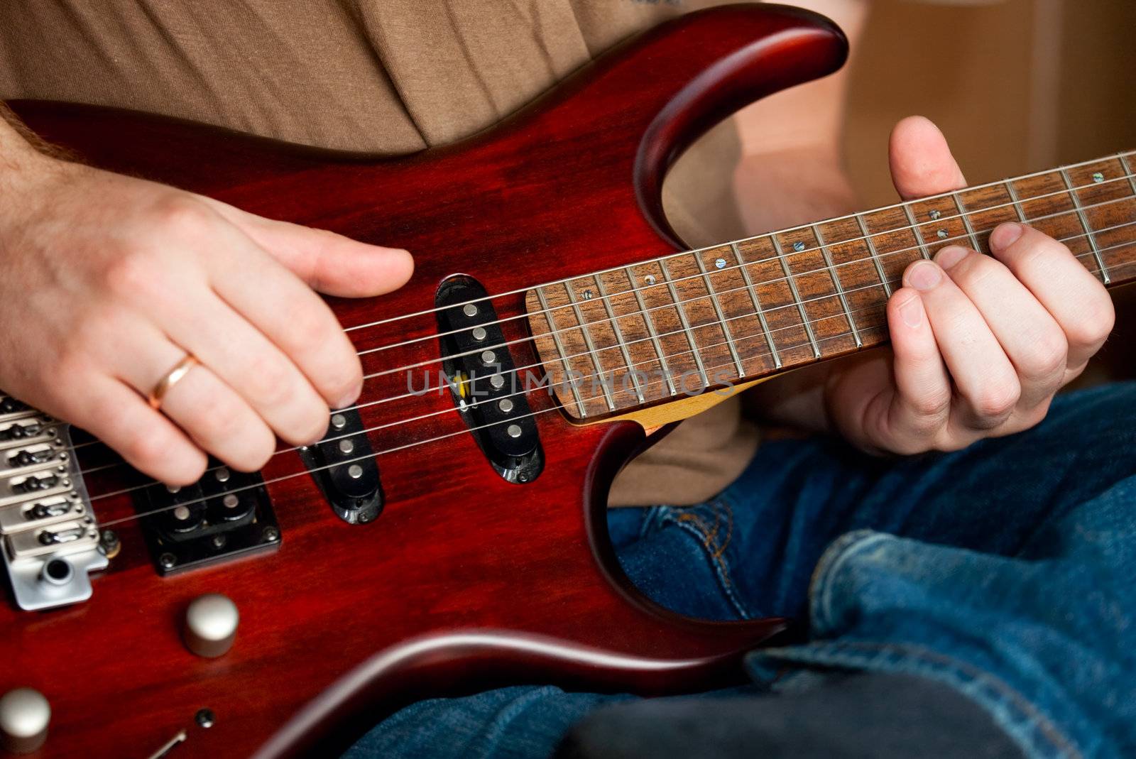 Musician playing an electric guitar cropped