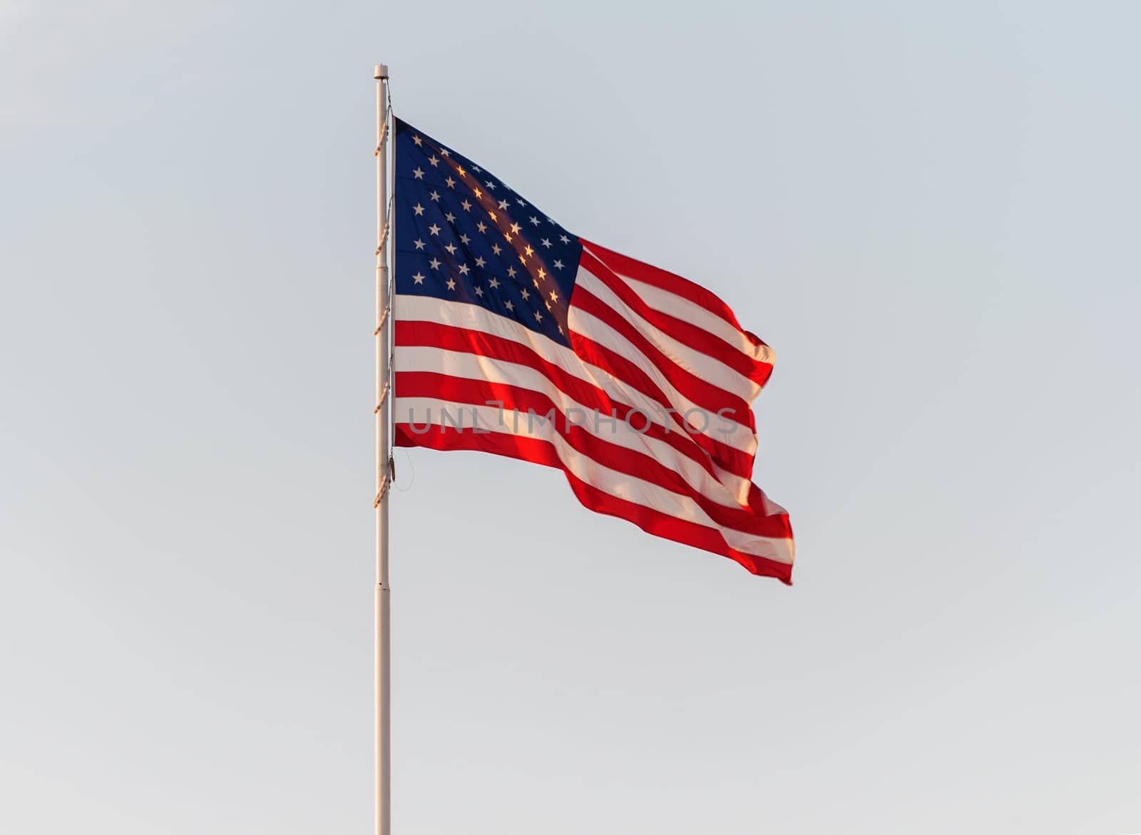American Flag Flying in front of a clear sky by Marcus