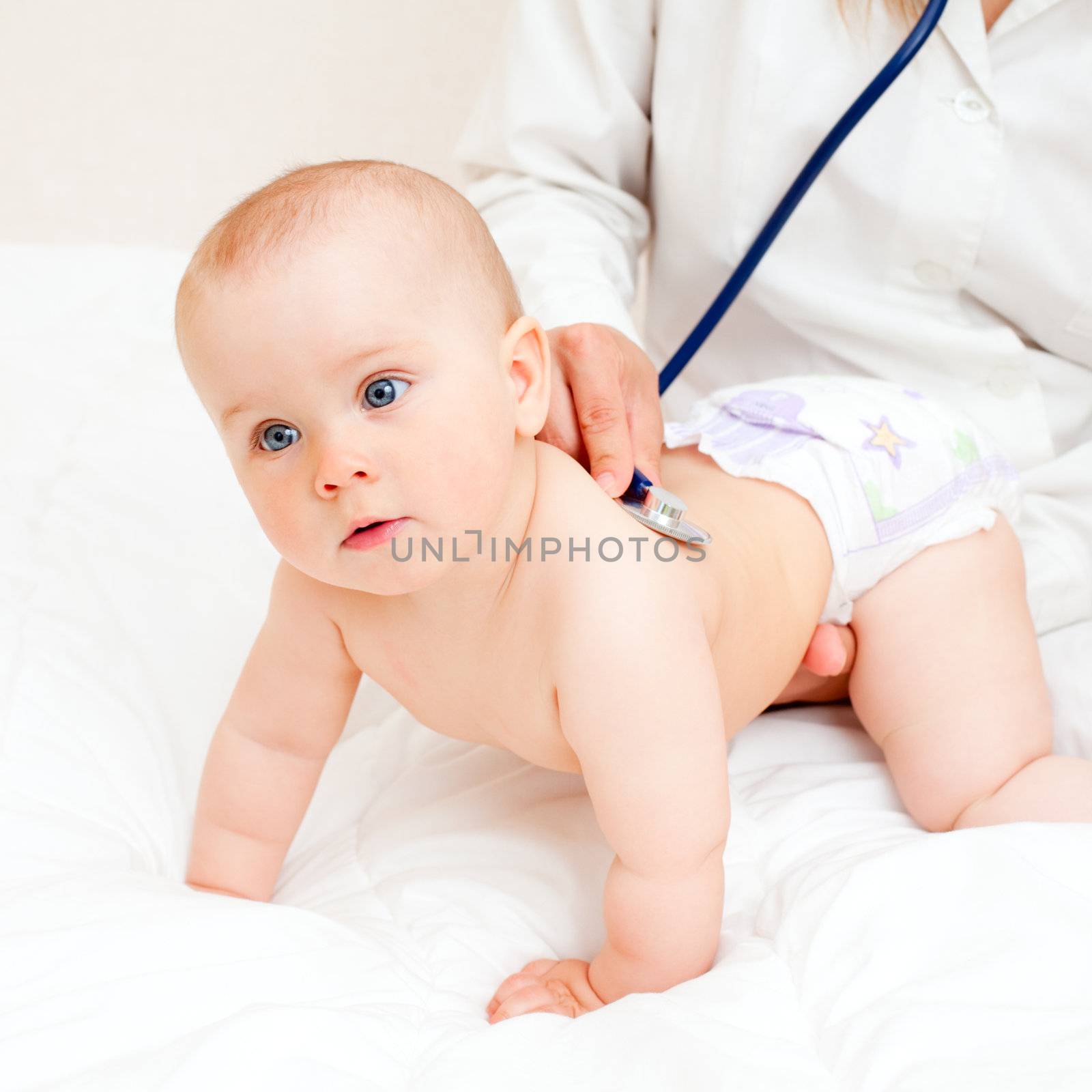 Children's doctor exams infant with stethoscope