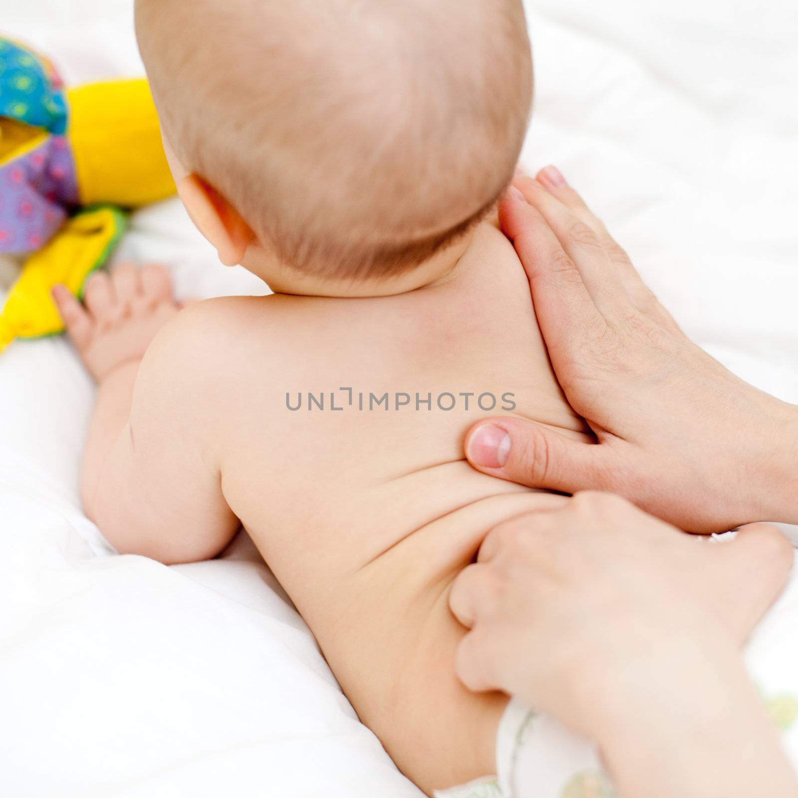 Masseuse massaging little baby girl, shallow focus