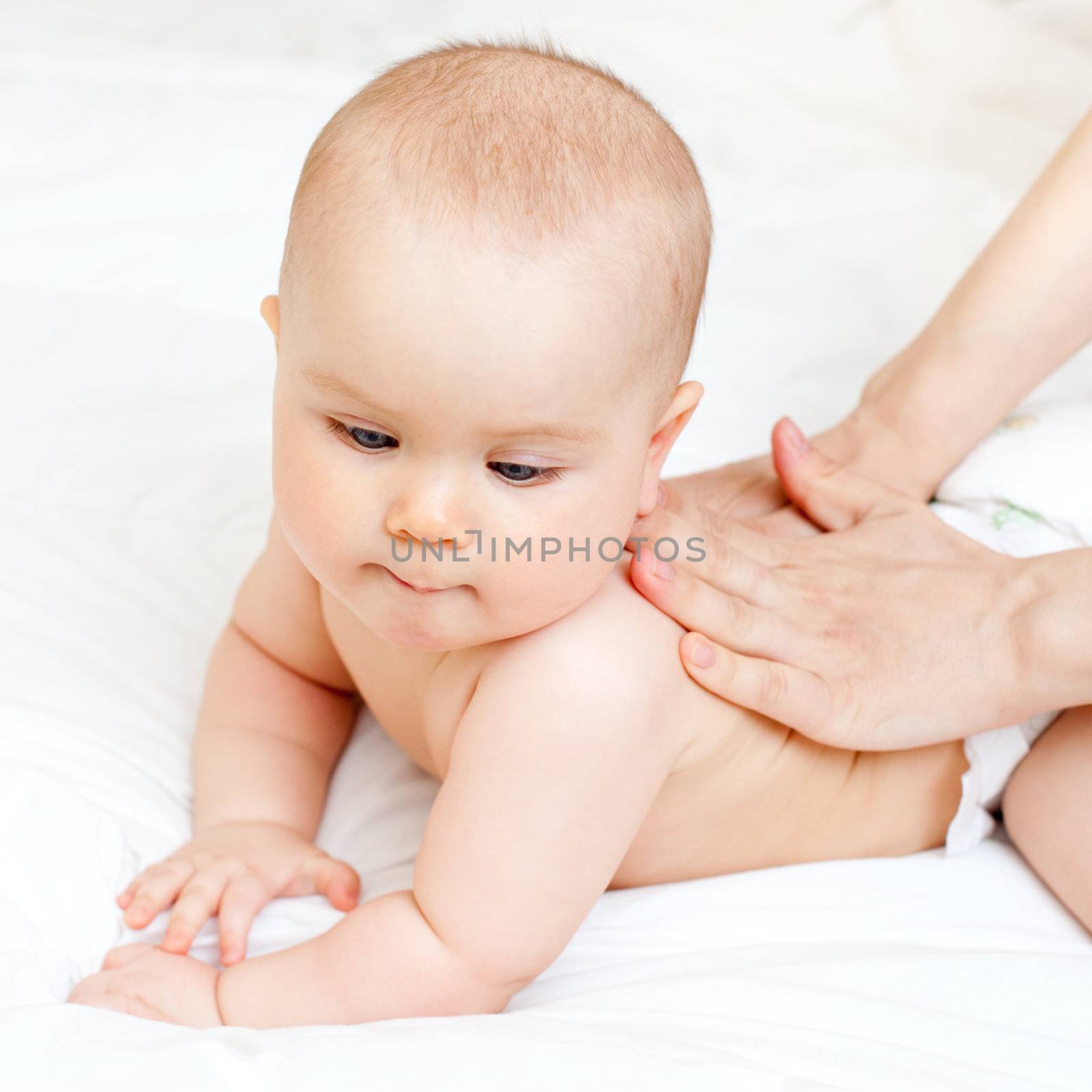 Masseuse massaging little baby girl, shallow focus