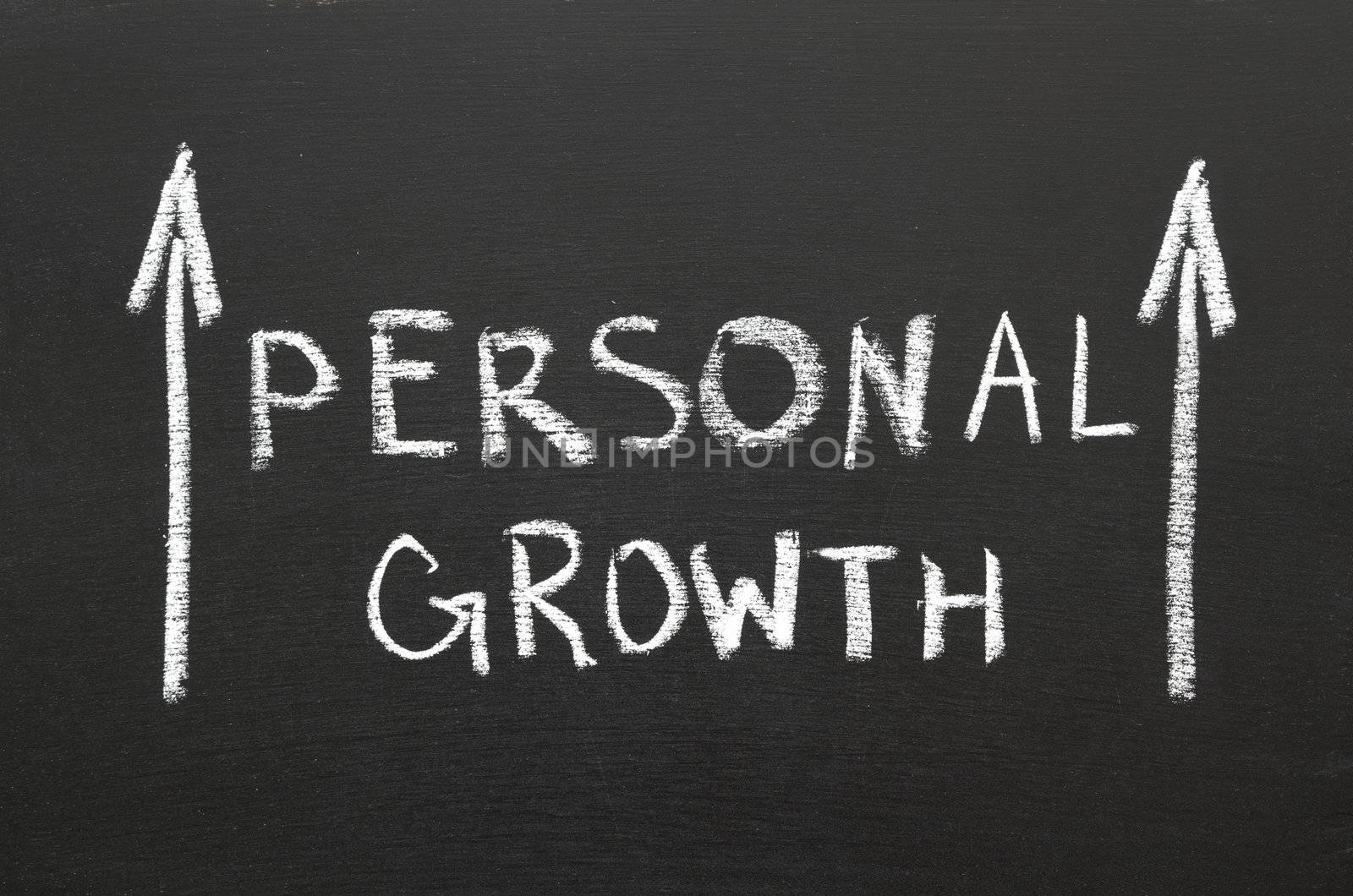 Personal growth phrase handwritten on the chalkboard with rising arrows