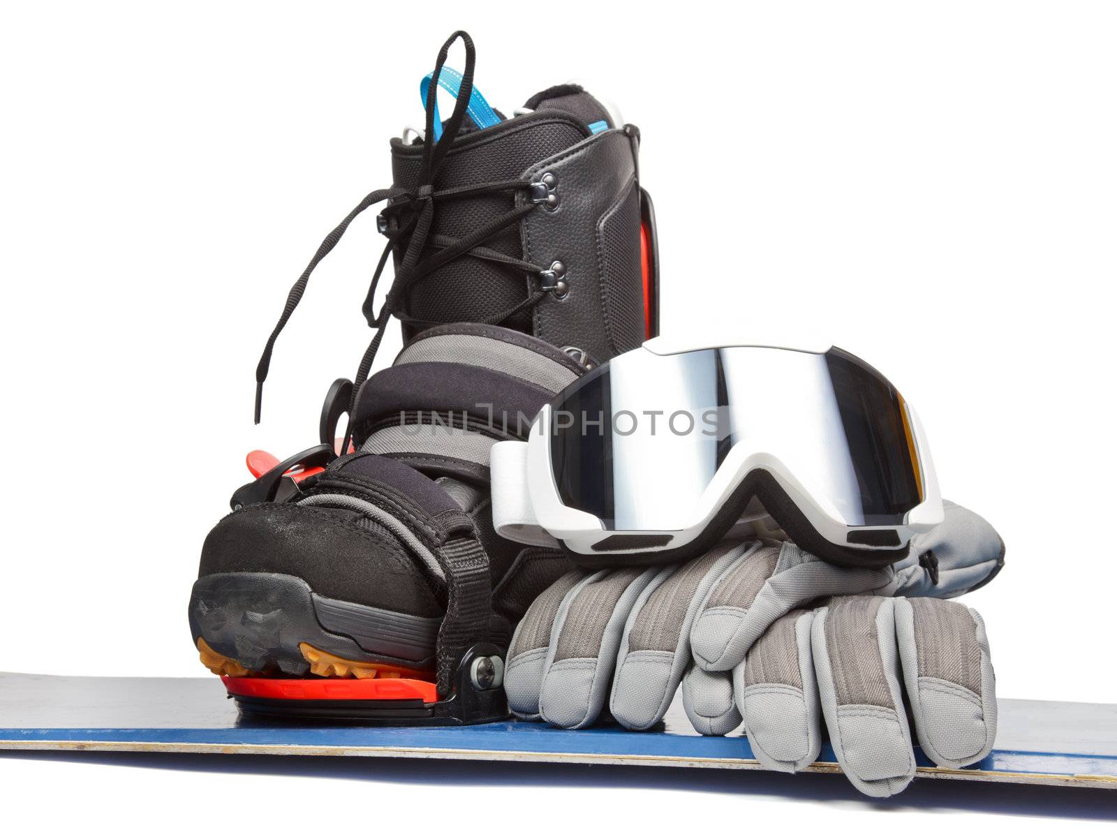 Snowboard with boot gloves and goggles on white background