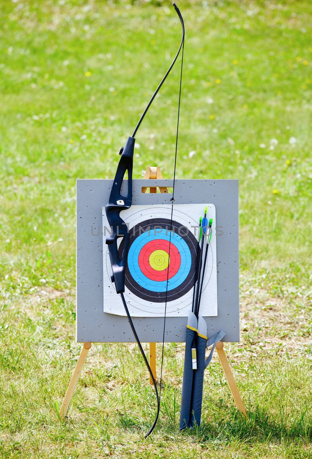 Bow and arrows with archery target outdoors