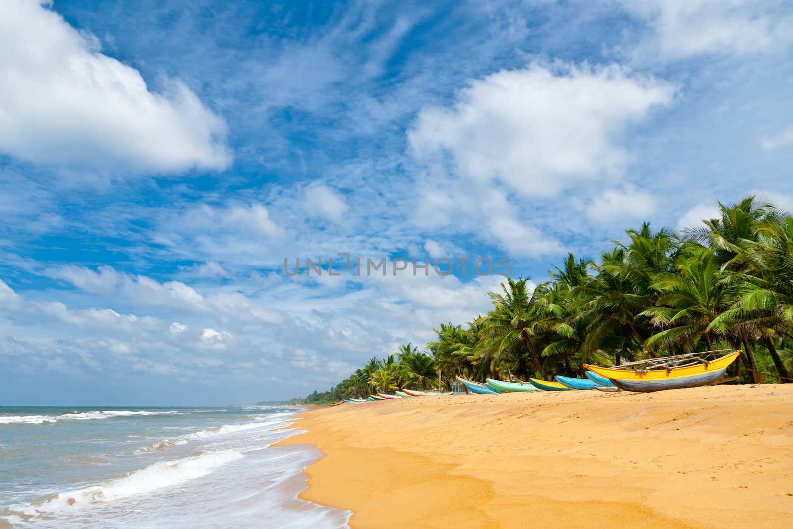 Fishing boats resting on empty beach in Sri Lanka