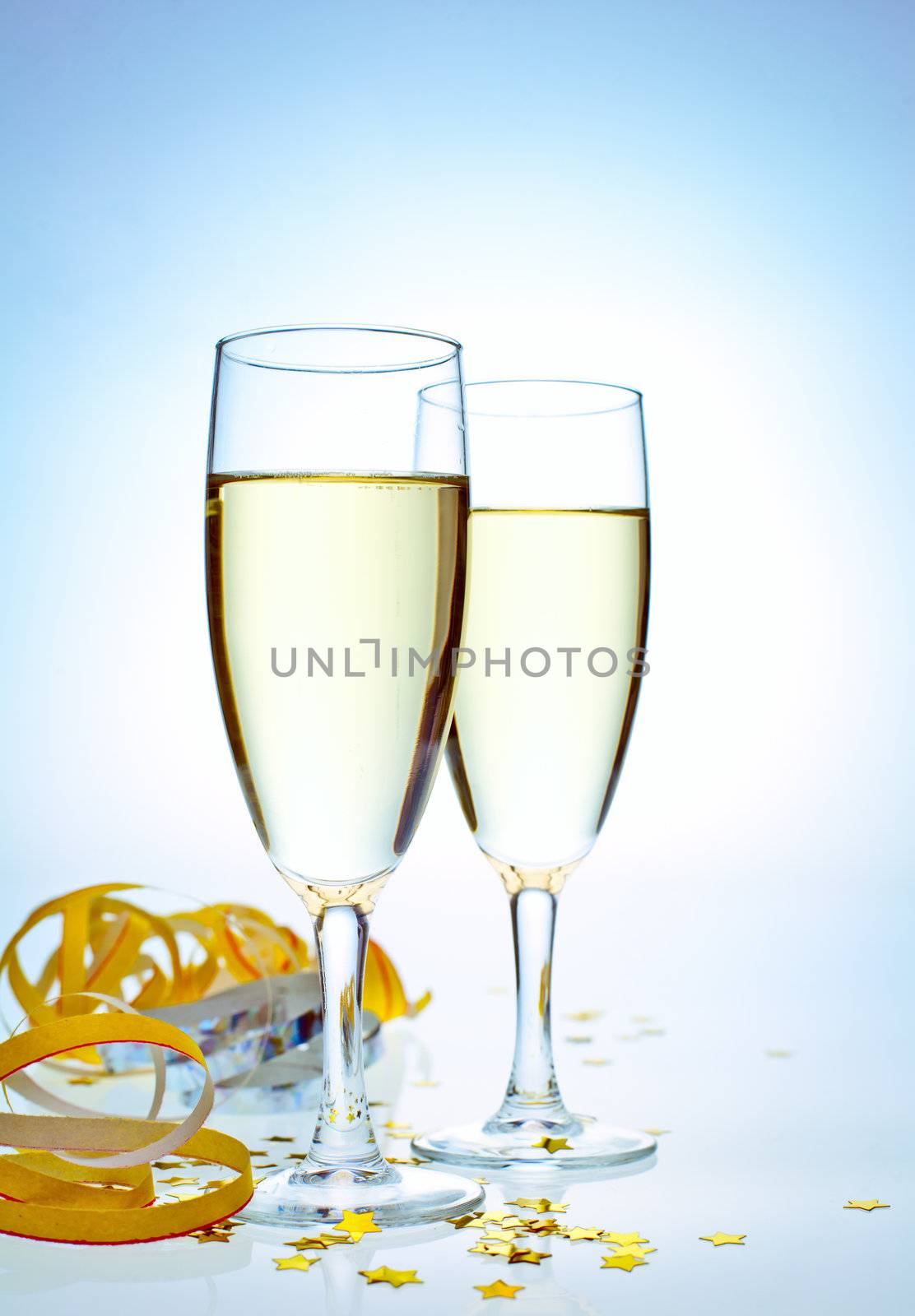 Two glasses of champagne with ribbons and confetti