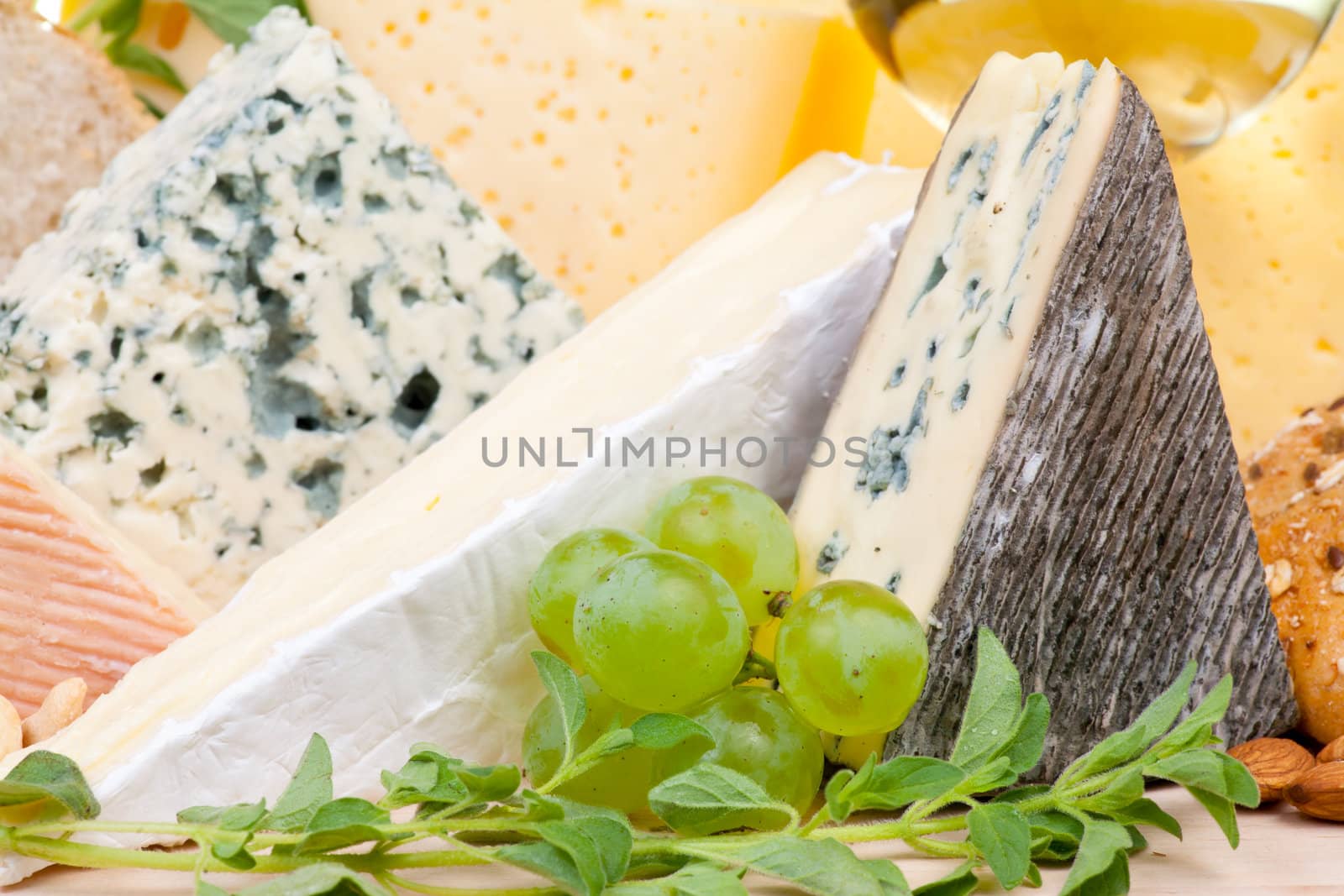 Various types of cheese with grapes close-up