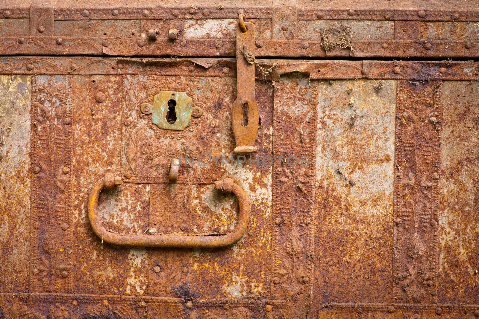 Front of old rusty chest with keyhole and bolt