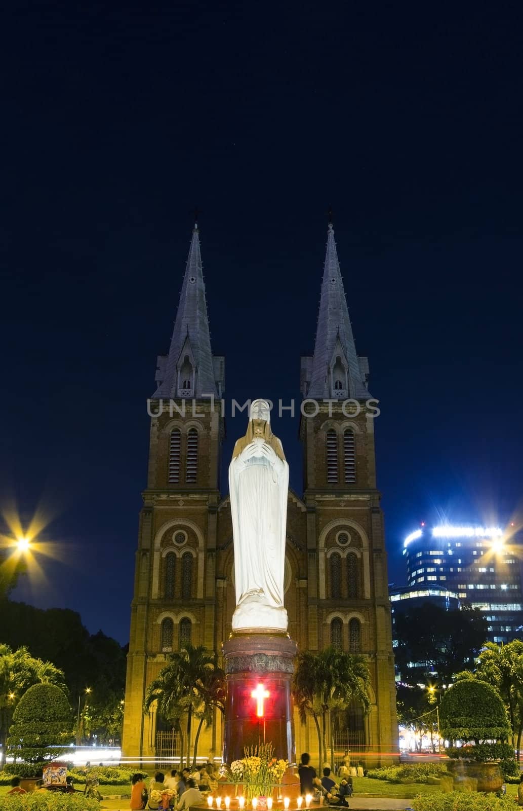 night view of notre dame of Saigon city with people praying by the statue