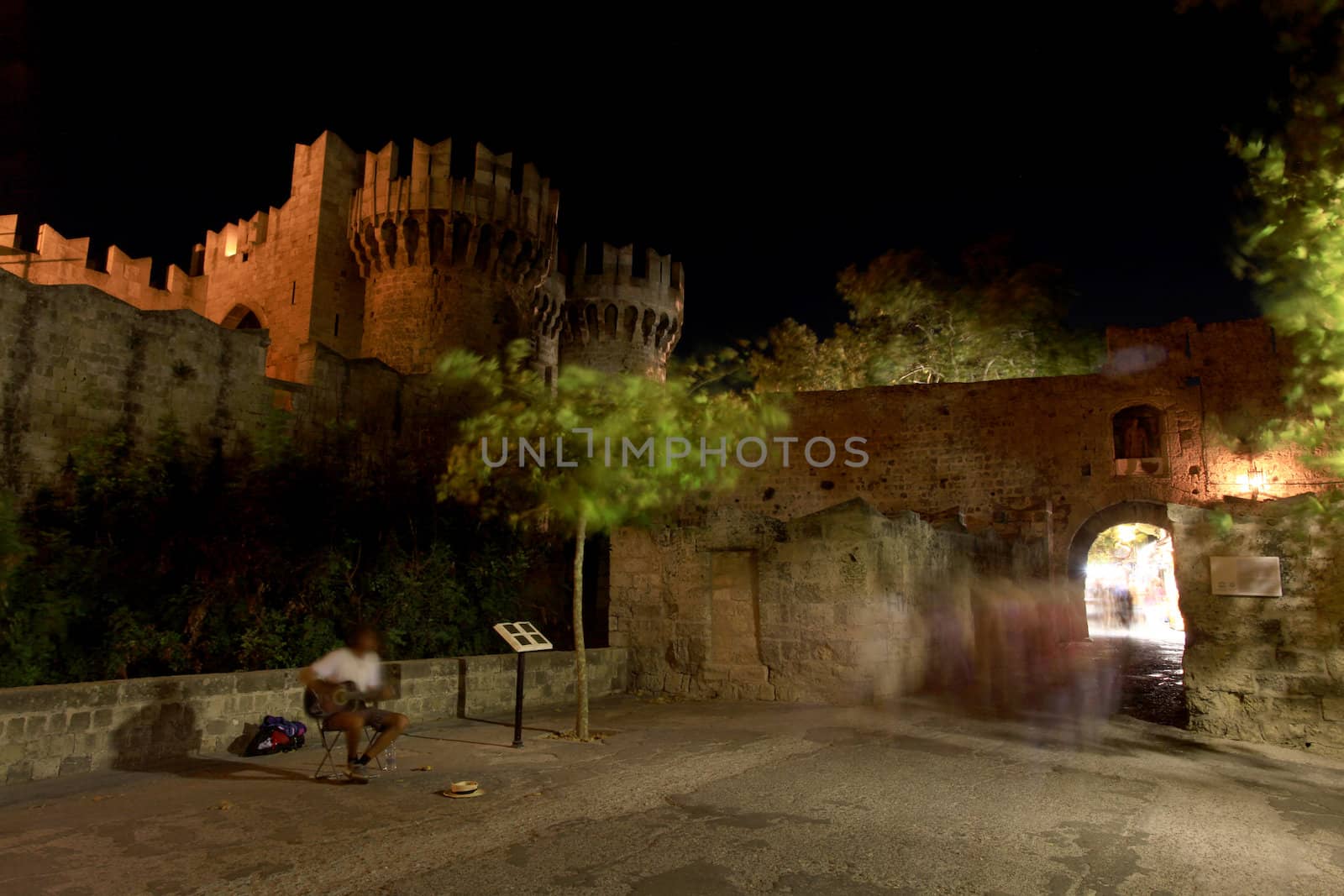 A long exposure motion blurs a local buslter outside the Place of the Grand Masters in Rhodes