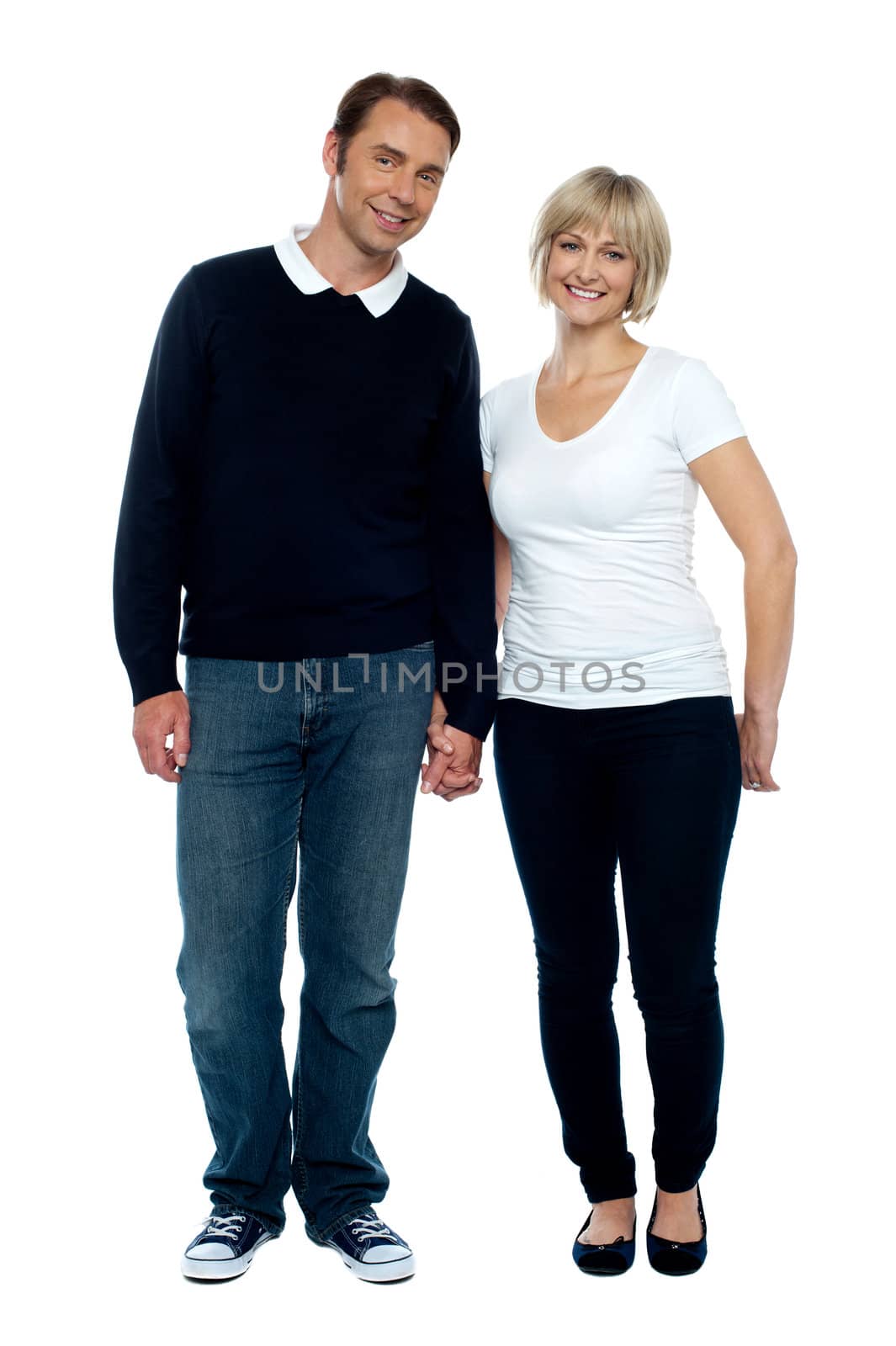 Middle aged couple posing with hand in hand by stockyimages