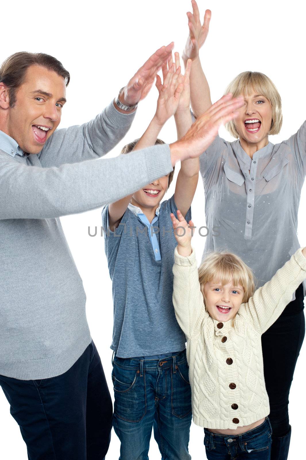 Jubilant family celebrating and partying indoors. Everyone throwing up their hands.