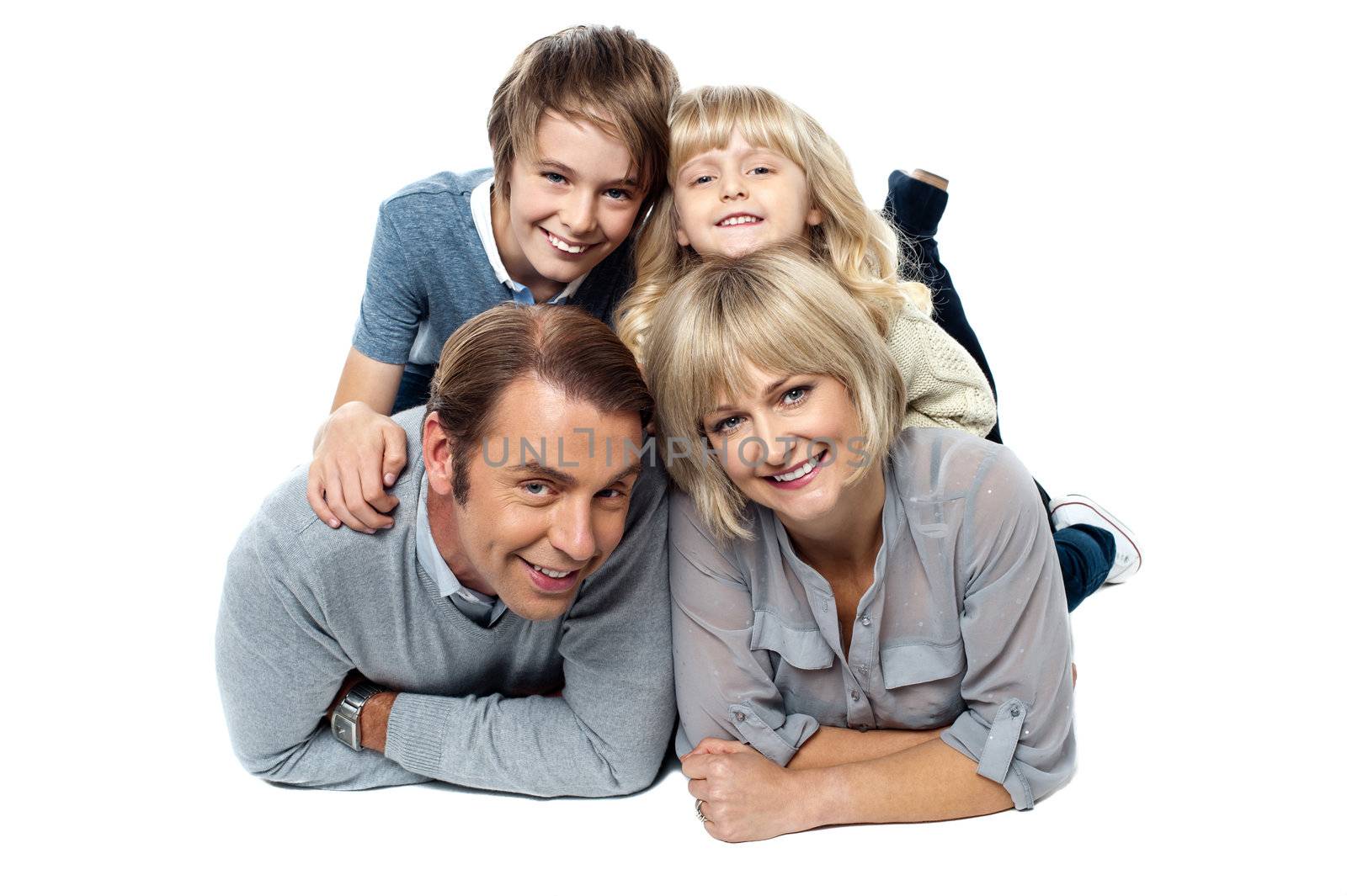 Adorable young kids piled on top of their parents. Studio shot