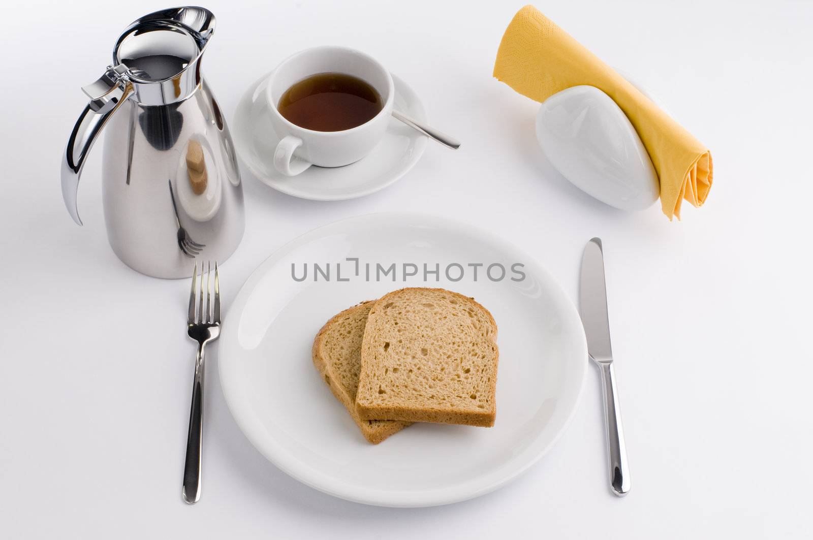 Breakfast table with thermos cup and white china, olive, tomato and bread