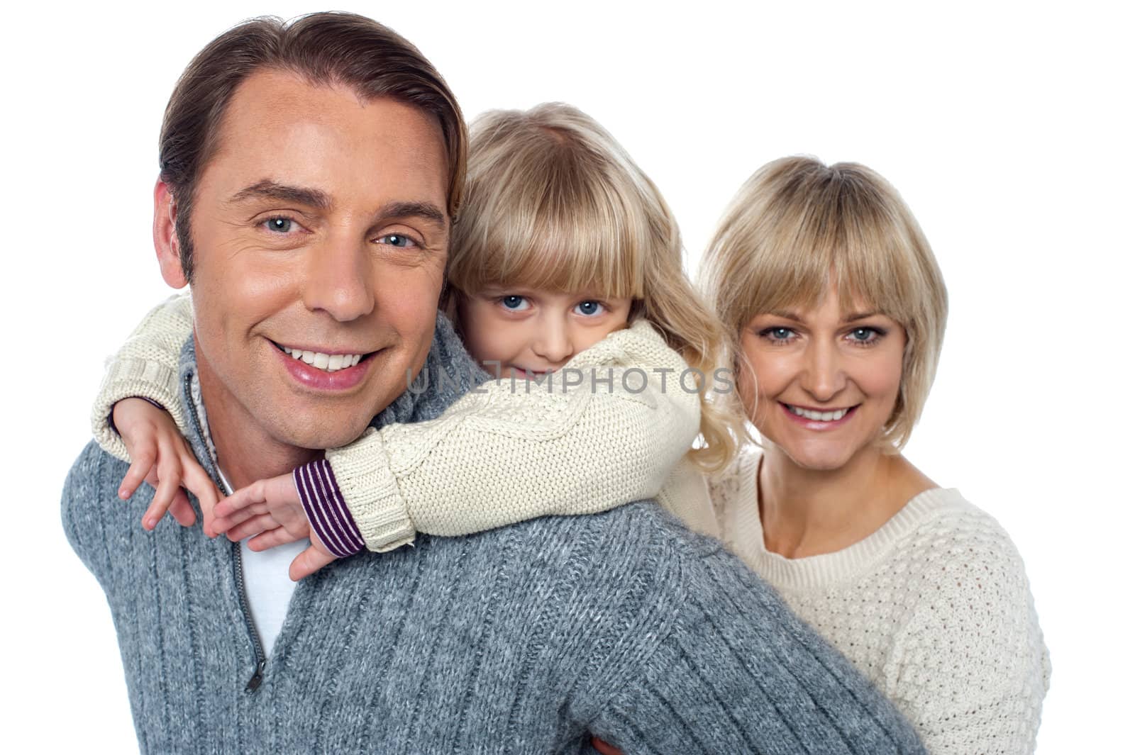 Fun loving family of three, girl piggybacking her father. by stockyimages