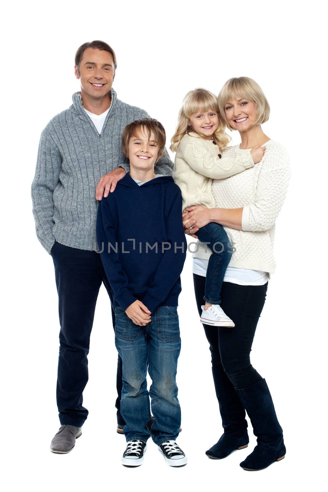 Full length portrait of a happy family posing in trendy winter wear outfits.