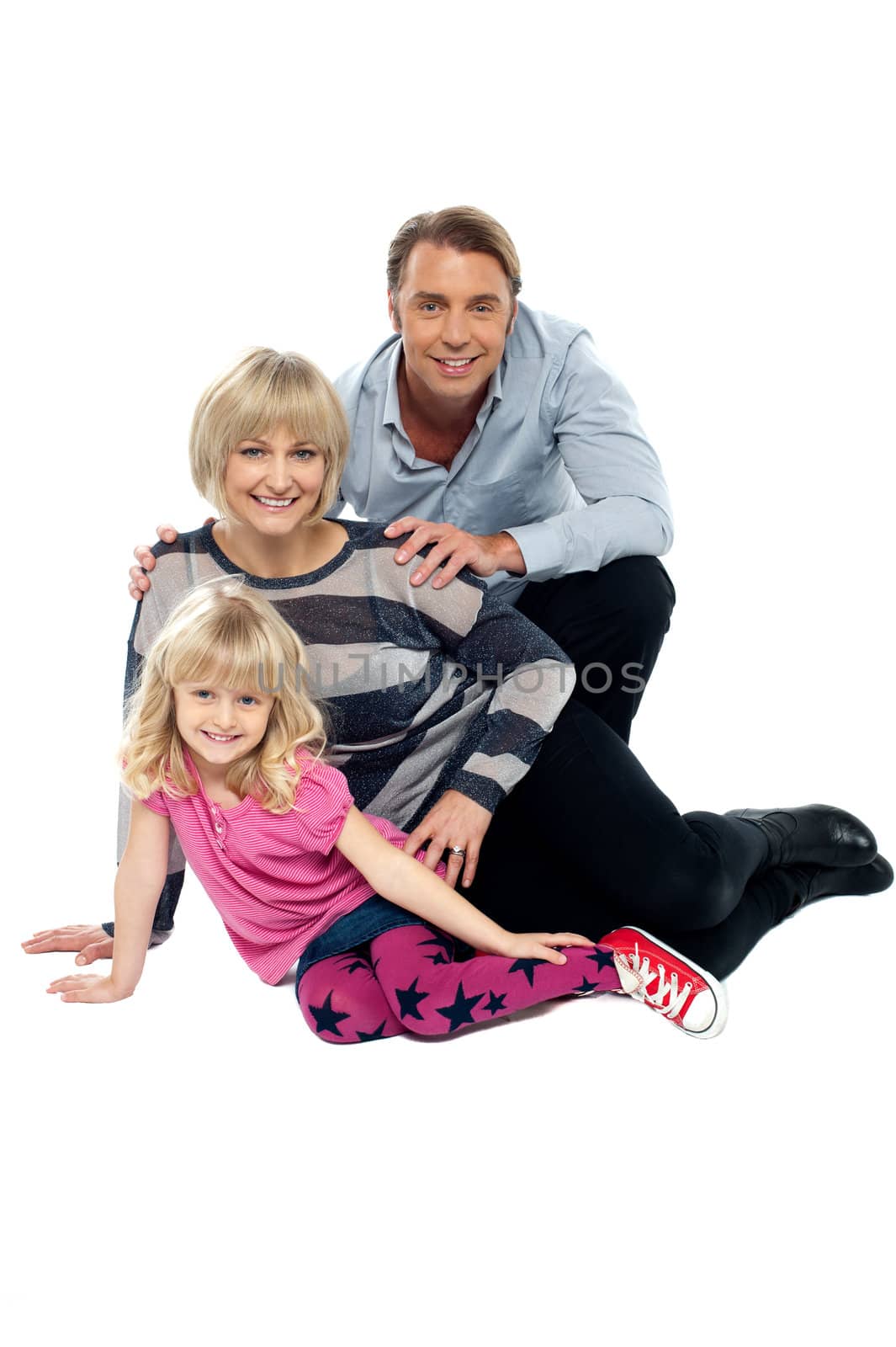 Young family of three posing indoors. Studio shot over white background.