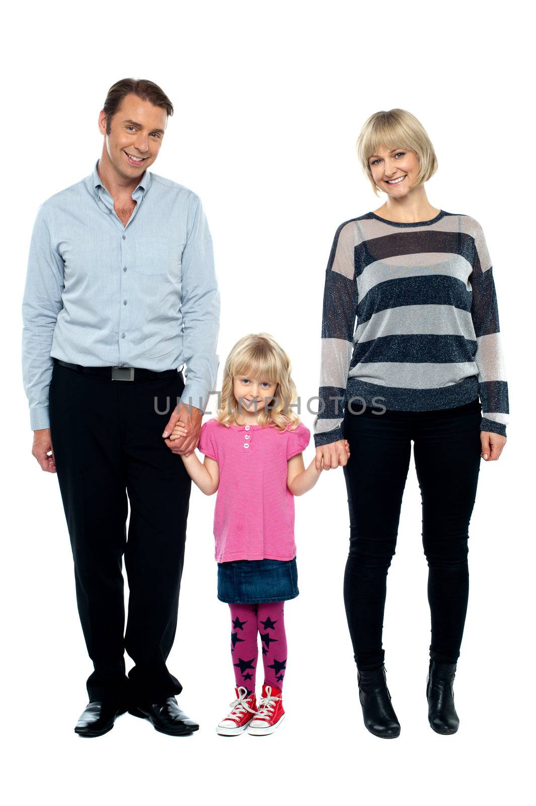 Cute daughter holding hands of her parents tightly. Full length studio shot.