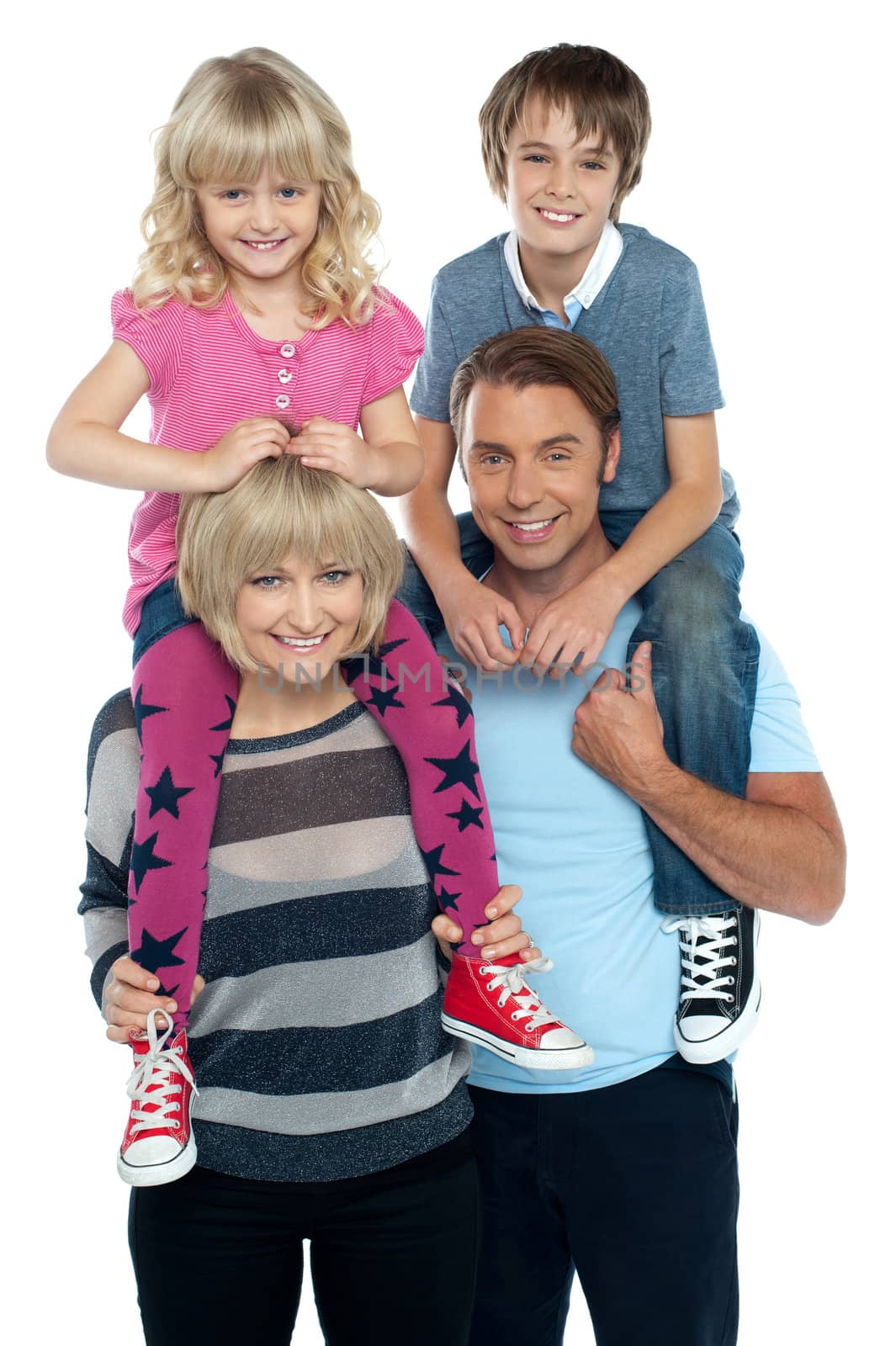 Cute daughter and son riding on their parents shoulders by stockyimages