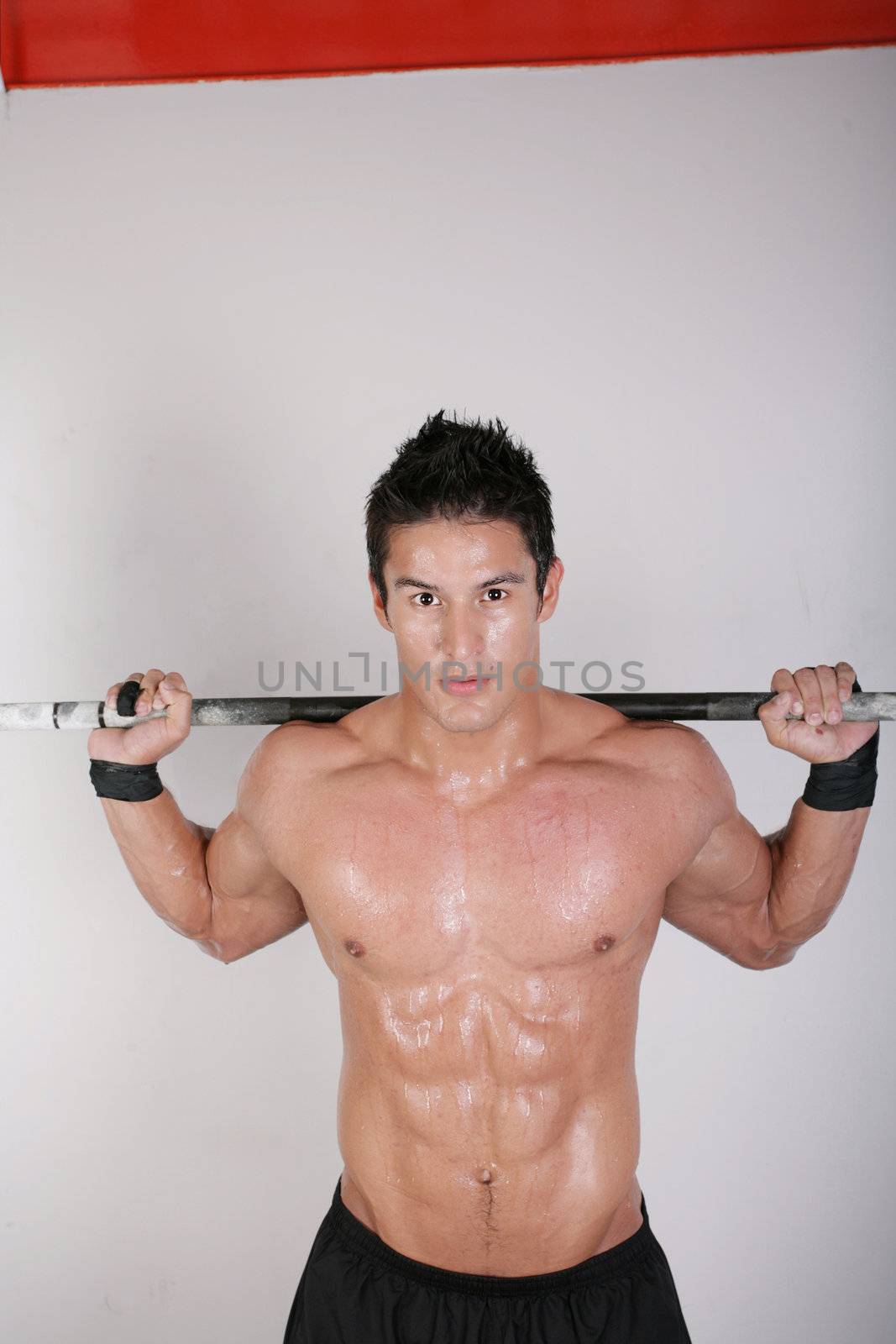Athletic young man doing workout with weights