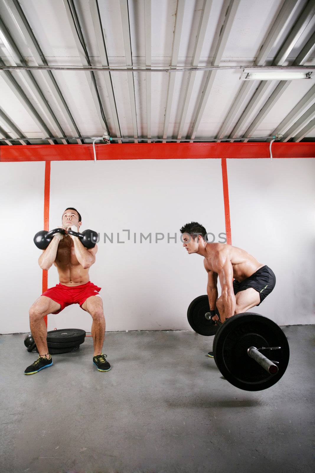 Group of two people exercising using barbells in gym and kettleb by dacasdo