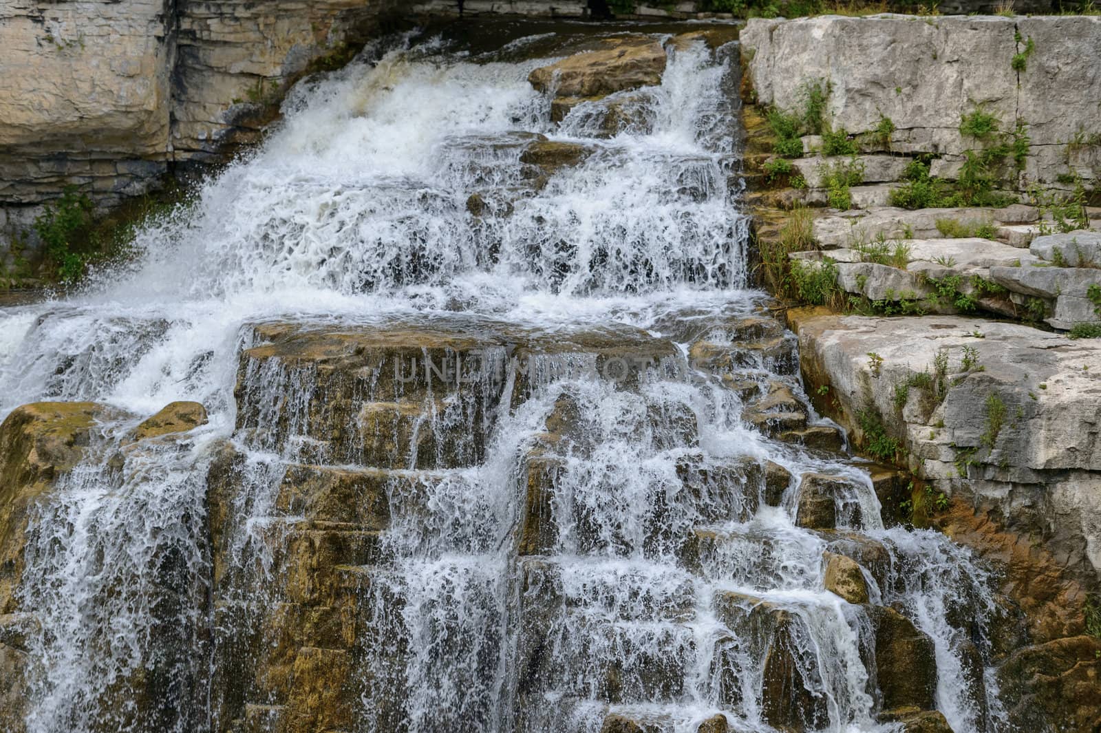 Inglis Falls in Owen Sound Ontario Canada. The Sydenham Rivers pours over rock formation of limestone shelves creating an 18 meter high cascade that has carved a deep gorge at the base of falls.