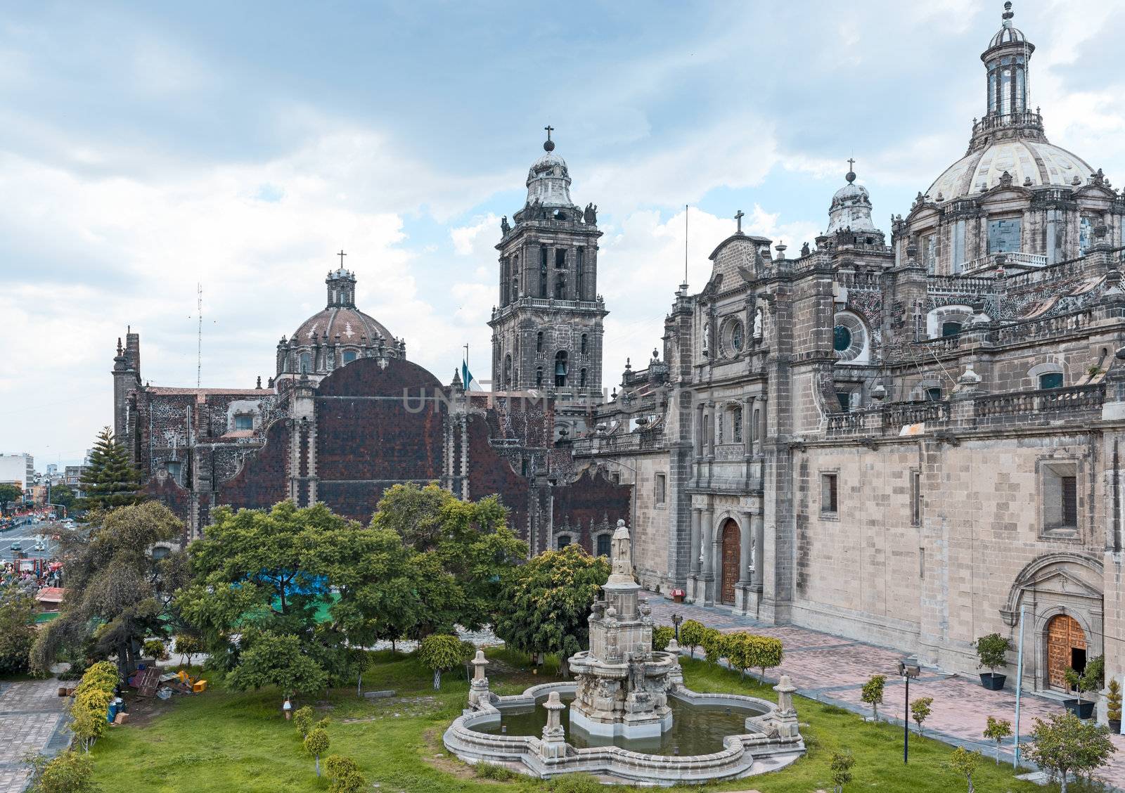 The Metropolitan Cathedral of the Assumption of Mary of Mexico City is the oldest and largest cathedral in the Americas and seat of the Roman Catholic Archdiocese of Mexico. It is situated atop the former Aztec sacred precinct near the Templo Mayor on the northern side of the Plaza de la Constitución in downtown Mexico City. The cathedral was built in sections from 1573 to 1813 around the original church that was constructed soon after the Spanish conquest of Tenochtitlán, eventually replacing it entirely. Spanish architect Claudio de Arciniega planned the construction, drawing inspiration from Gothic cathedrals in Spain.