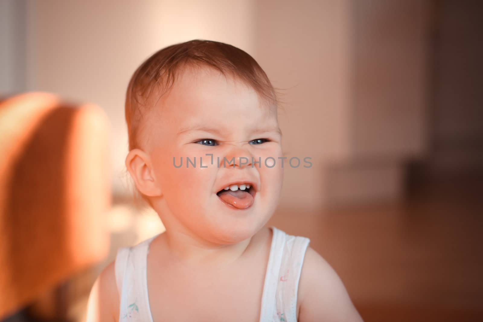 Beautiful expressive adorable happy cute laughing smiling baby infant face showing tongue