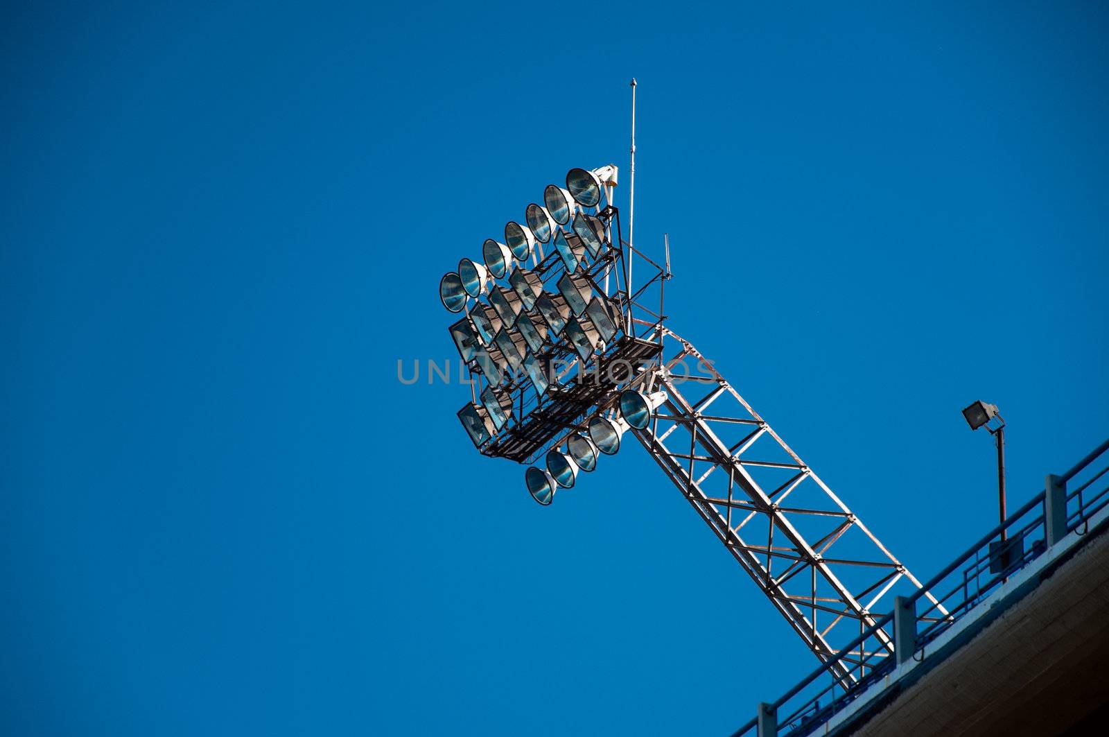 Stadium lights set against a beautiful blue sky