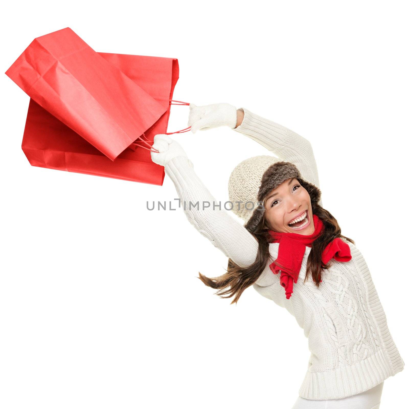 Winter and christmas shopping. Woman holding red shopping bags happy, ecstatic and cheering with energy, Isolated on white background.